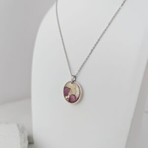 PXL_20261013_172517979 - Blue Pendulum Jewelries Silver chain necklace with an oval pendant resting on a white surface, pendant featuring a purple-toned stone design