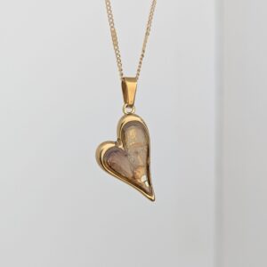 PXL_20261013_173220249PORTRAIT - Blue Pendulum Jewelries Gold heart-shaped pendant on a delicate gold chain hanging against a pale background.