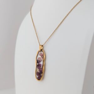PXL_20261014_170429843PORTRAIT - Blue Pendulum Jewelries Gold necklace with a teardrop pendant featuring pink marbled inlay on a white background.